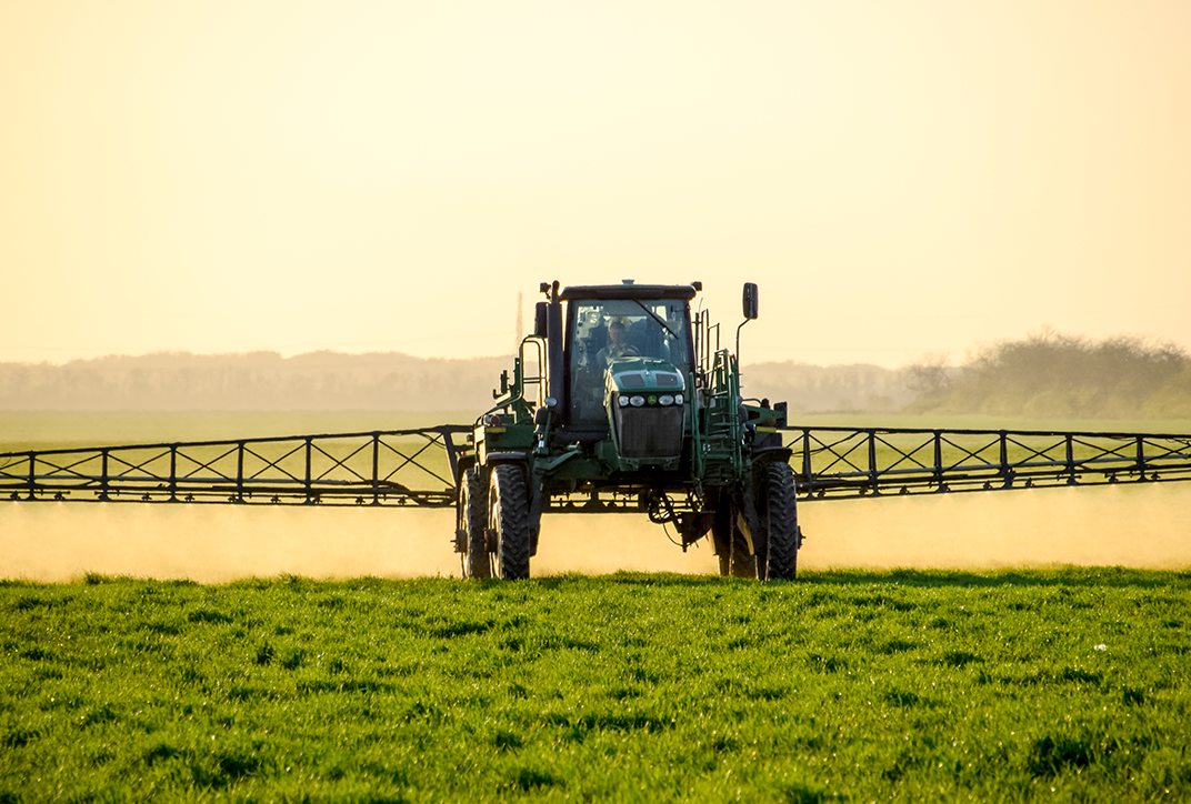 Ein Landwirtschaftsfahrzeug beim Düngen eines Feldes.