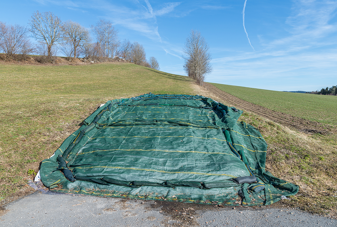 A field with a plastic film covering plants.