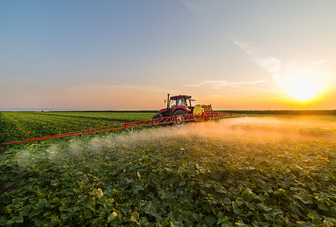 A tractor spraying fertilizer in a field.