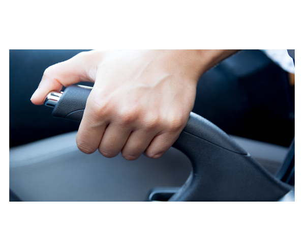 Eine Hand betätigt die Handbremse eines Autos.