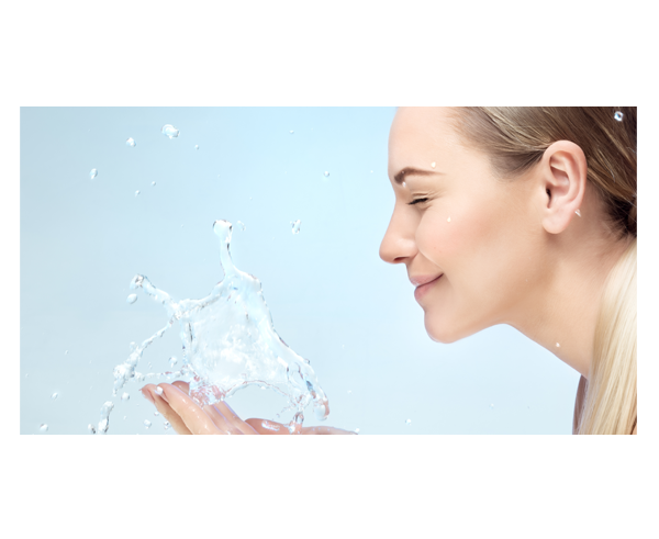A lady splashing water onto her face with both hands.