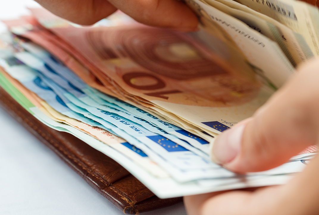 A person counting various euro bills.