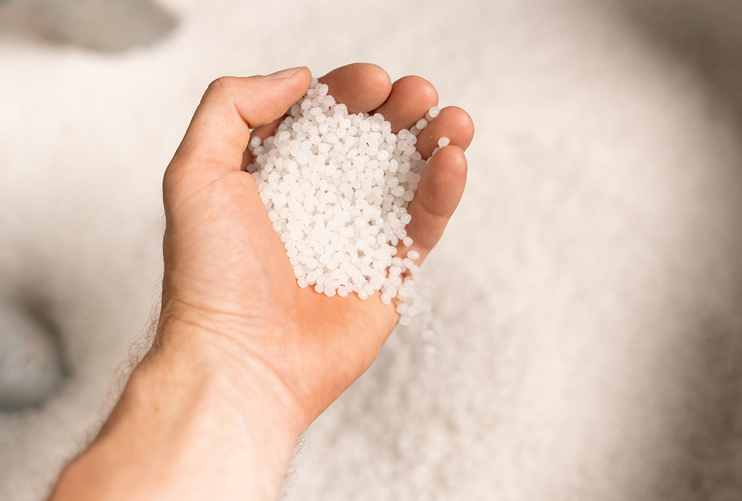 A hand holding PVC granules.