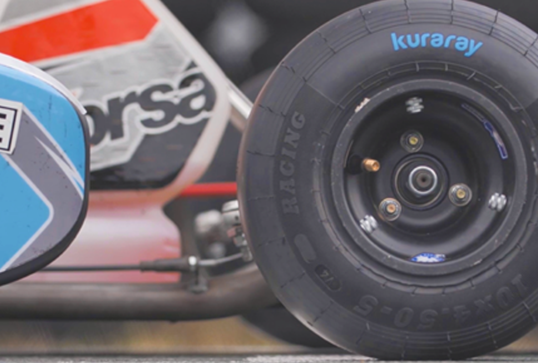 Side view of a racing car. On the right is a close-up of a tire.