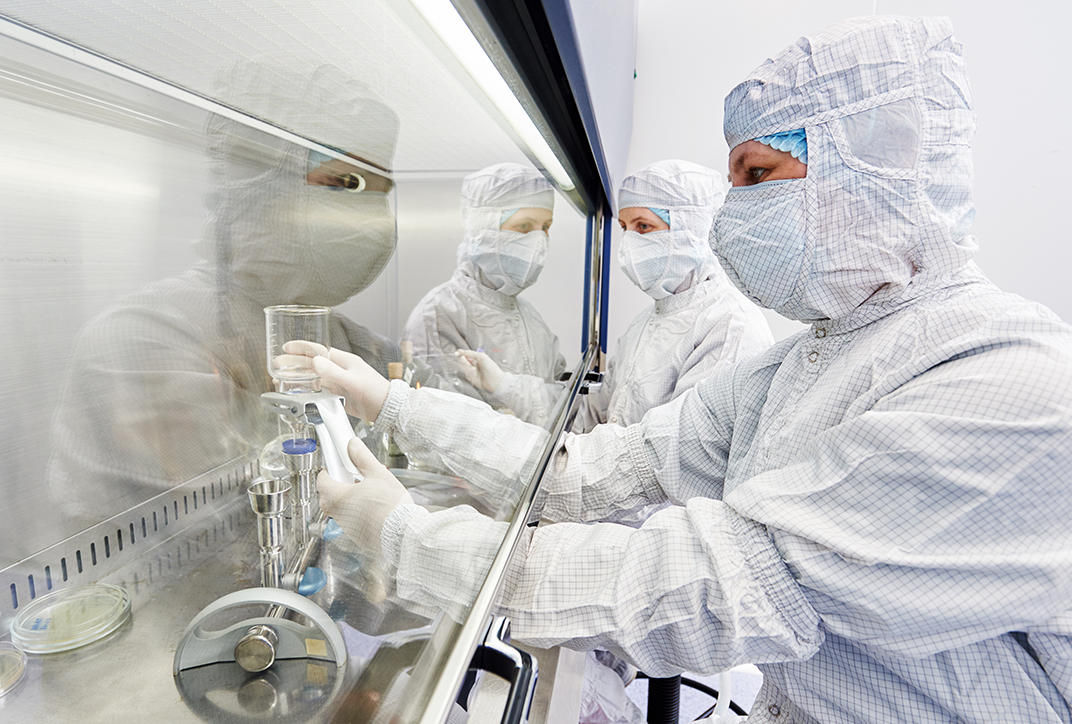 A person in a lab wearing a protective suit.